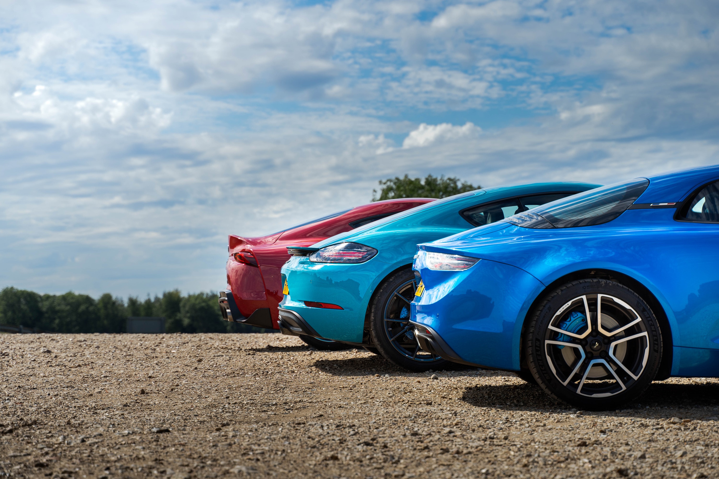 Rear view of Toyota Supra, Porsche 718 and Alpine A110